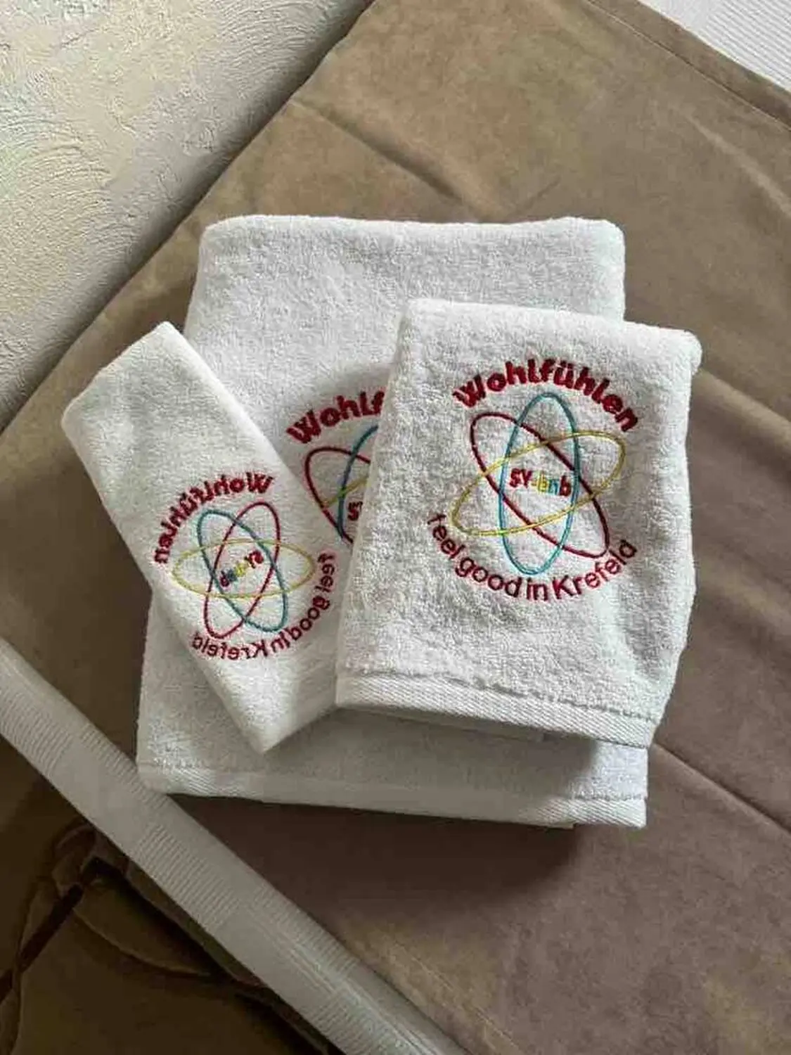 Wohlfühlen – weiße Handtücher mit aufgedrucktem Logo
